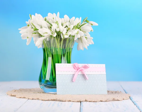 Schöne Schneeglöckchen in der Vase, auf Holztisch auf hellem Hintergrund — Stockfoto