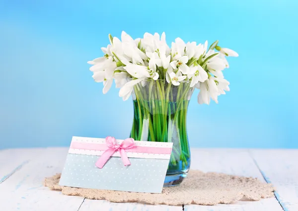 Schöne Schneeglöckchen in der Vase, auf Holztisch auf hellem Hintergrund — Stockfoto