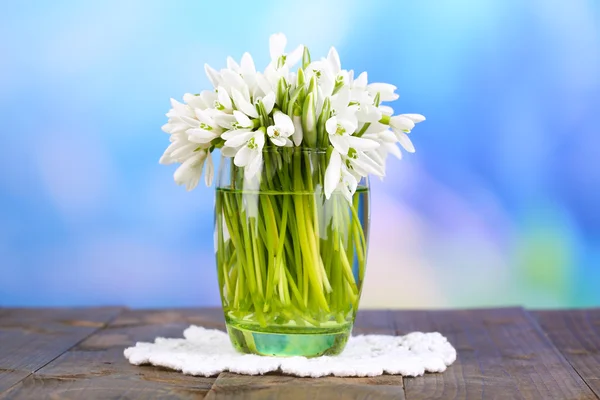 Όμορφη snowdrops στο βάζο, σε ξύλινο τραπέζι σε φωτεινό φόντο — Φωτογραφία Αρχείου