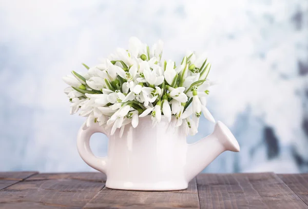 Beaux gouttes de neige dans un vase, sur la table sur fond lumineux — Photo