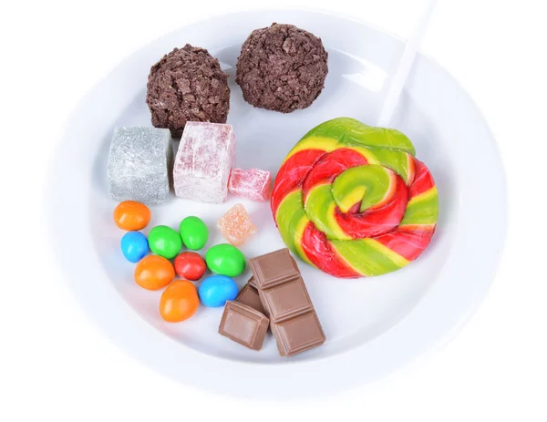 Различные сладости на тарелке изолированы на белом — стоковое фото