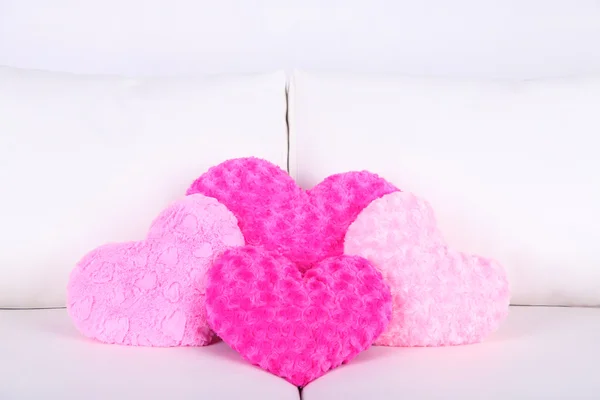 Almohadas en forma de corazón rosa en sofá blanco — Foto de Stock