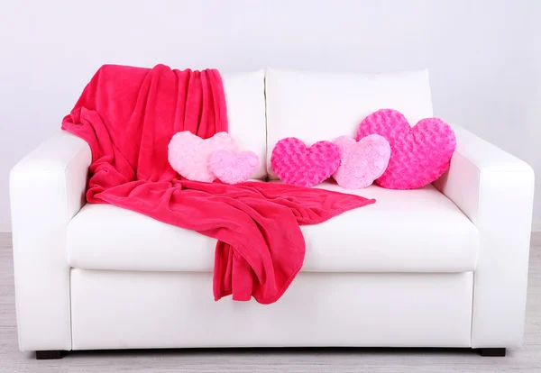 Pink heart shaped pillows on white sofa — Stock Photo, Image