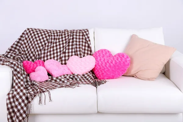 Almohadas en forma de corazón rosa en sofá blanco — Foto de Stock