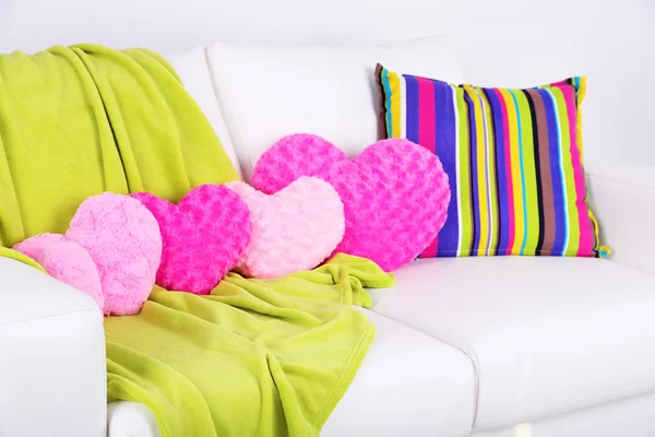 Roze hart gevormde kussens, plaid op witte sofa — Stockfoto