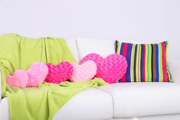 粉色心形枕头，在白色的沙发上的格子 — 图库照片