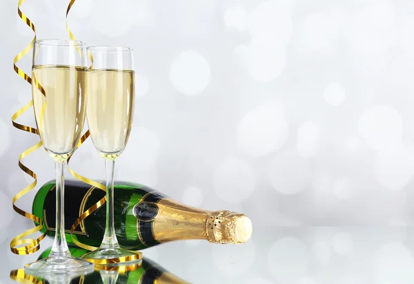 Glasses and bottle of champagne on light background — Stock Photo, Image