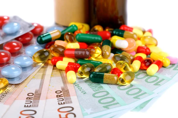 Léky na předpis na peníze pozadí zastupující rostoucí náklady na zdravotní péči. izolované na bílém — Stock fotografie