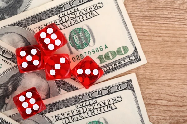 红色骰子和美元在木制的背景 — 图库照片