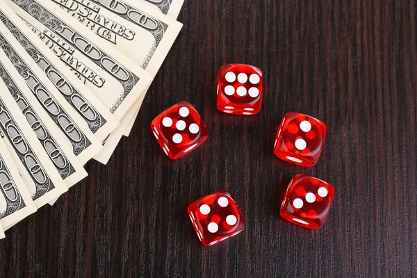 Red dices and dollars on wooden background — Stock Photo, Image