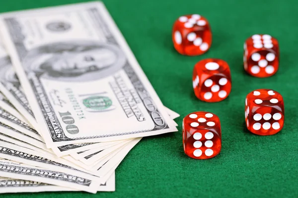 Red dices and dollars on green background — Stock Photo, Image