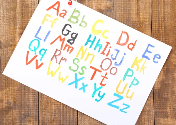 Alphabet watercolors on wooden background — Stock Photo, Image