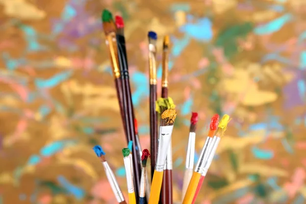 Wiele szczotki w farby na multicolor drewniane tła — Zdjęcie stockowe