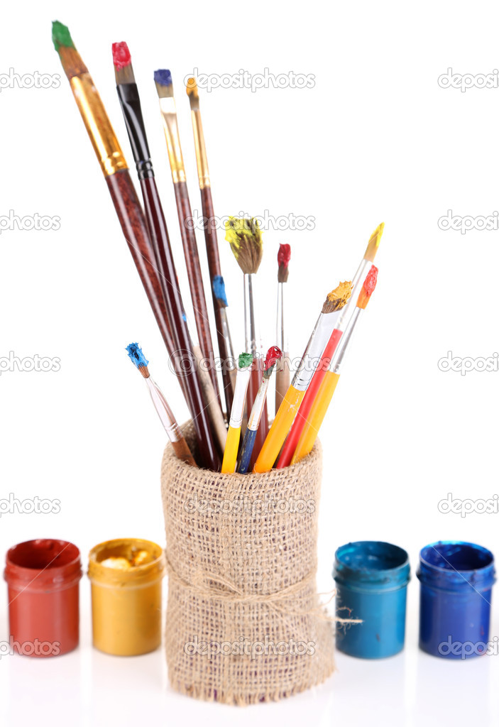 Brushes with paints in vase isolated on white