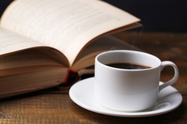 tabloda gri arka plan üzerinde kitapla sıcak çay