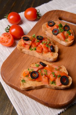 Kesme tahtasında domatesli lezzetli bruschetta.