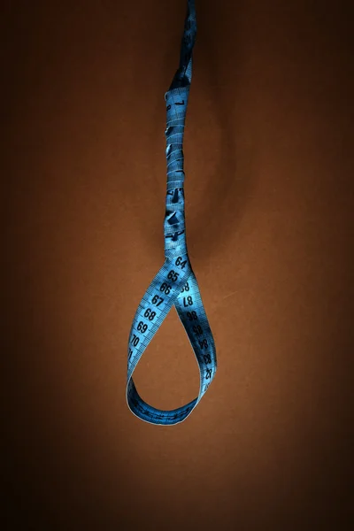 Tape measure noose on brown background - diet concept — Stock Photo, Image