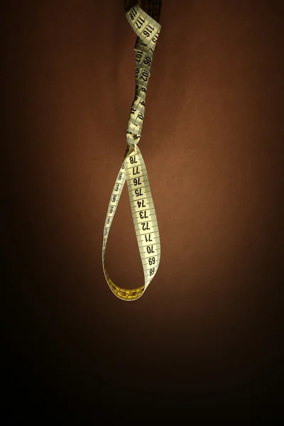 Tape measure noose on brown background - diet concept — Stock Photo, Image