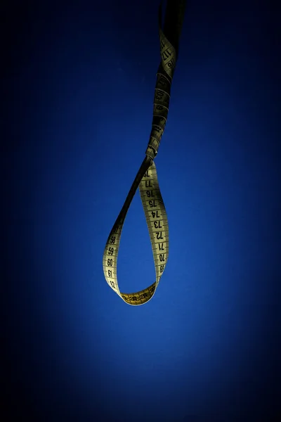 Tape measure noose on blue background - diet concept — Stock Photo, Image