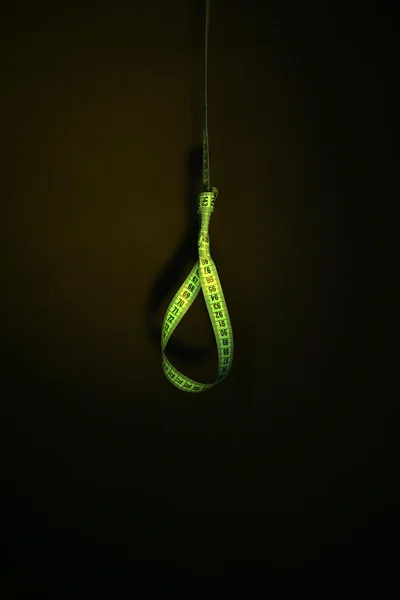 Tape measure noose on dark background - diet concept — Stock Photo, Image