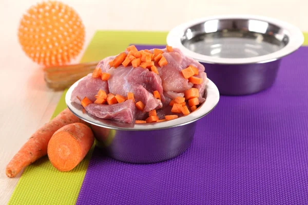 Comida natural para animais de estimação e água em tigelas no chão — Fotografia de Stock