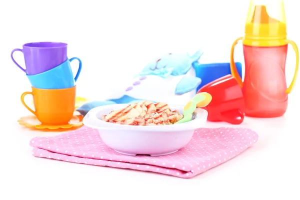 Tigela de mingau de cereal para bebê em brinquedos fundo — Fotografia de Stock