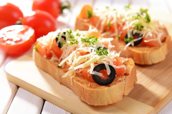 도마 위에 토마토를 얹어 놓은 맛있는 브루스 체타 — 스톡 사진