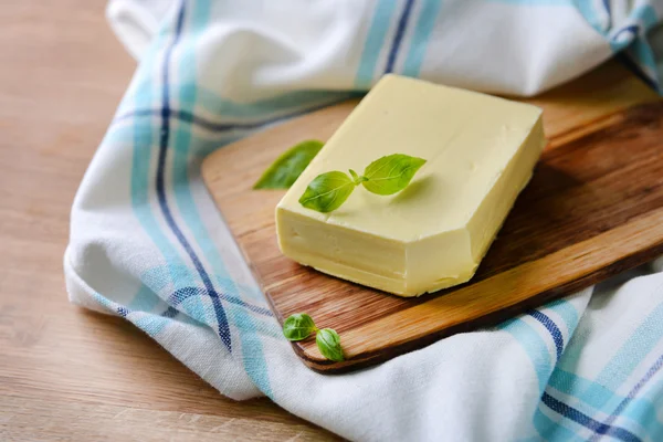 Pyszne masło na drewnianą deską do krojenia — Zdjęcie stockowe