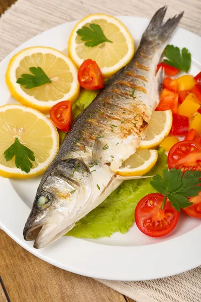 Delicious grilled fish on plate on table close-up — Stock Photo, Image