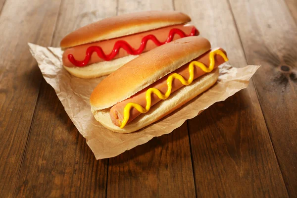 Sabrosos perritos calientes en mesa de madera — Foto de Stock