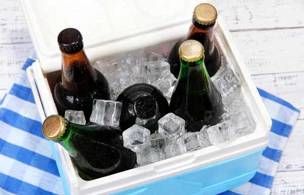 冰胸部充满了饮料装在瓶子里颜色餐巾，木制的背景上 — 图库照片