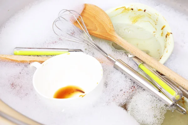 Utensils soaking in kitchen sink — Stock Photo, Image