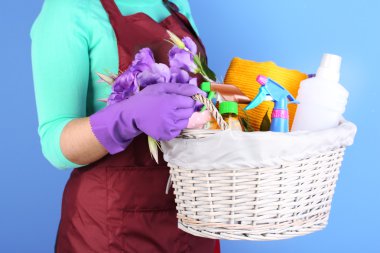 renkli arka plan üzerinde vernik ile sepeti tutan ev kadını. bahar temizliği kavramsal fotoğraf. 