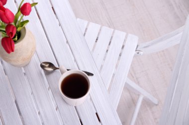 sıcak bir içecek, mum ve ahşap masa arka plan üzerinde çiçek Kupası ile kompozisyon