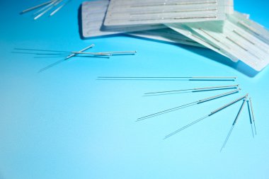 için mavi arka plan üzerinde akupunktur iğneleri