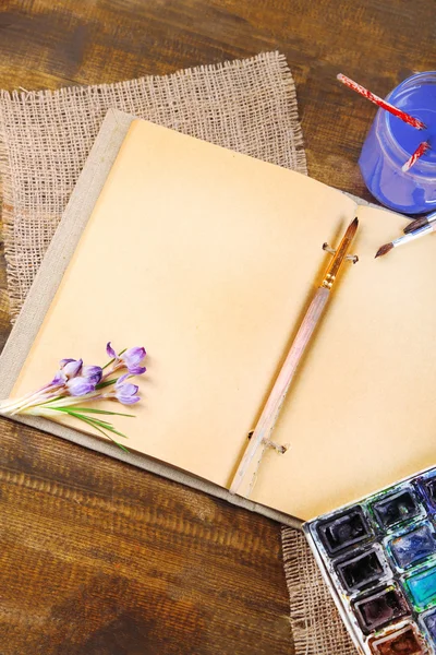 Renkli suluboya, fırçalar ve ahşap zemin üzerinde sketcher kompozisyonu — Stok fotoğraf