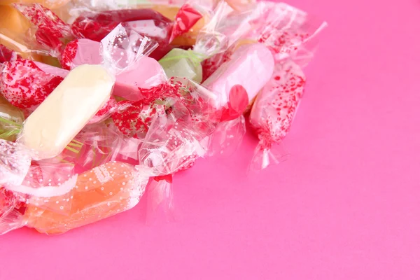 Välsmakande godis på rosa bakgrund — Stockfoto