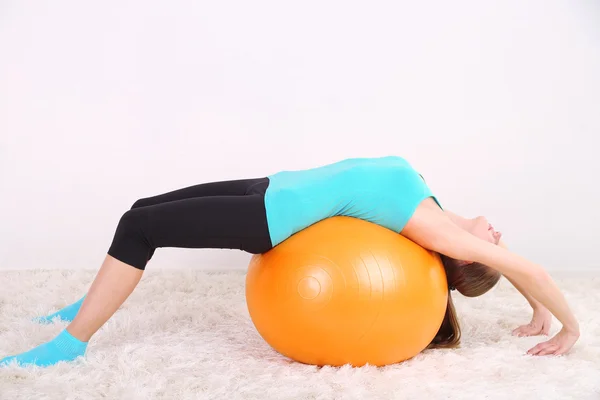 用橙色的球，在健身房锻炼的年轻美丽健身女孩 — 图库照片