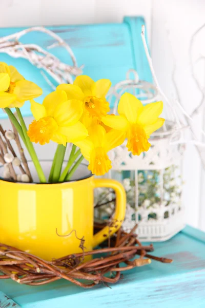 Beautiful spring flowers on blue old wooden chair — Stock Photo, Image