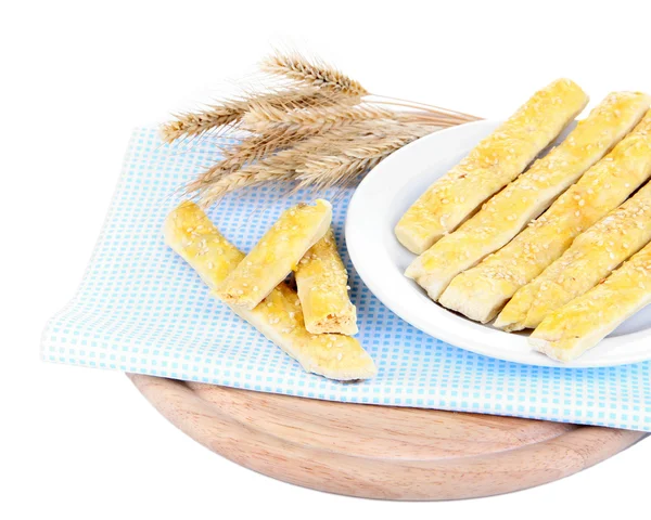 Sabrosos palitos de pan en el plato en la servilleta de color, aislado en blanco — Foto de Stock
