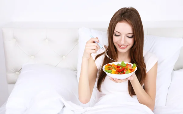 Junge schöne Frau im Bett mit leichtem Frühstück — Stockfoto