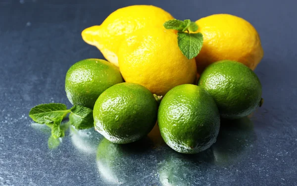 Limoni e lime su fondo scuro — Foto Stock
