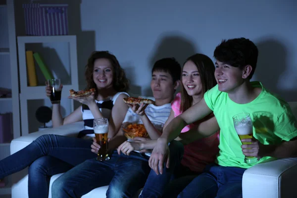 Groep van jonge vrienden televisiekijken thuis van schoensmeer-uiterlijk — Stockfoto