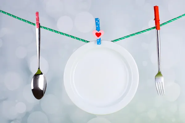 Tableware dried on rope on bright background — Stock Photo, Image