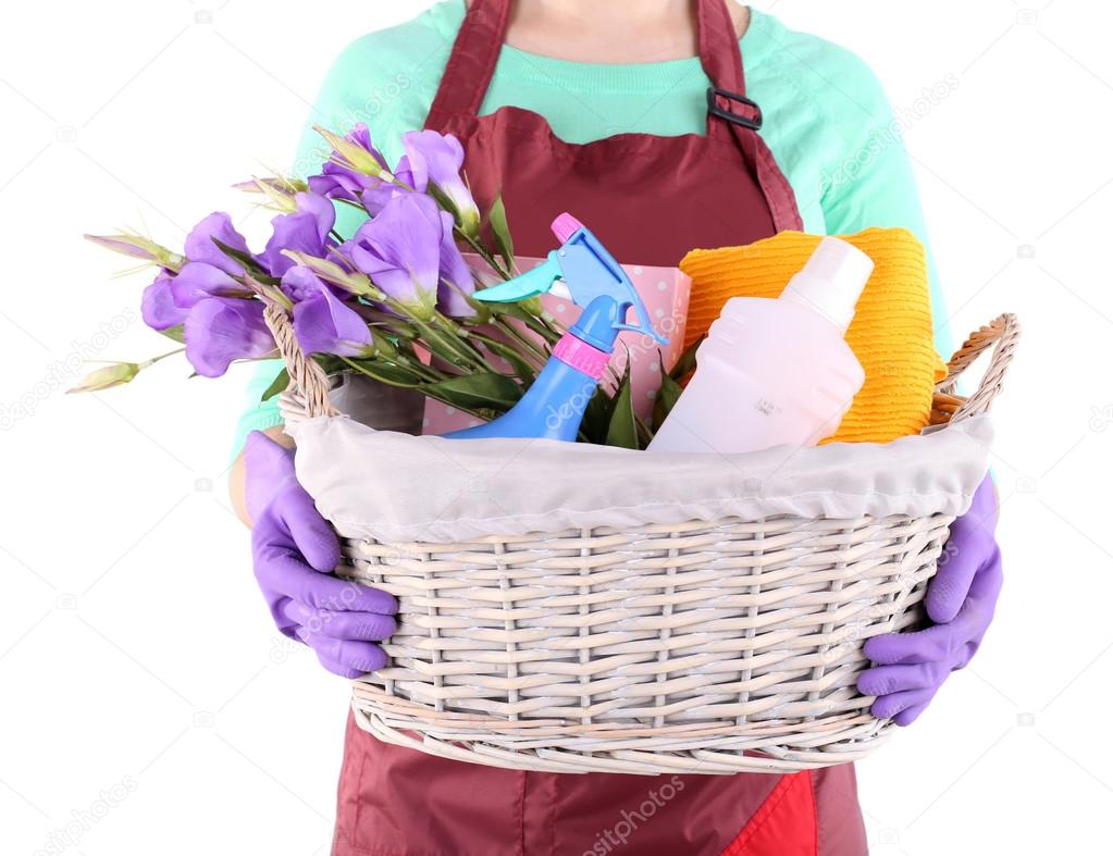 Housewife holding basket with cleaning equipment. Conceptual photo of spring cleaning. Isolated on white