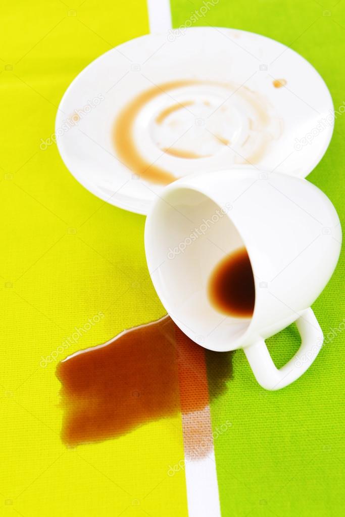 Overturned cup of coffee on table close-up