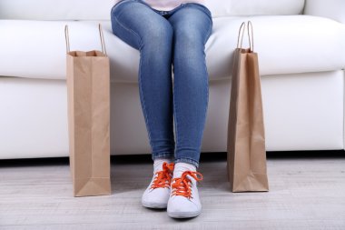 kadın kanepe yakın çekim alışveriş torbaları ile oturmak
