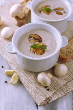 Beyaz tencerelerde mantar çorbası, peçete, ahşap zemin