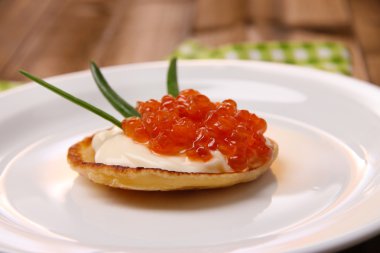 Kırmızı havyar ve mayo, yeşil soğan, plaka, ahşap arka plan üzerinde renkli peçete üzerinde gözleme