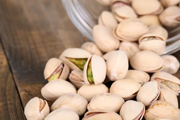 Nueces de pistacho en frasco de vidrio en la mesa de cerca — Foto de Stock